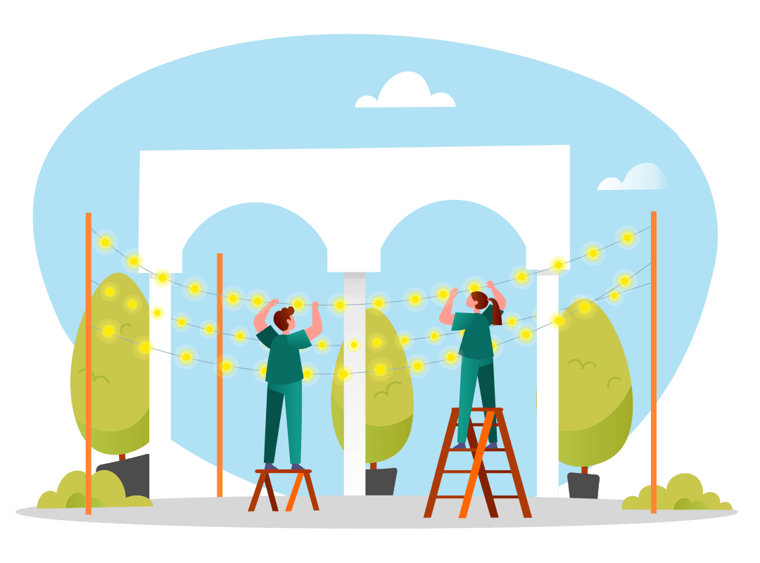 Two people stand on ladders hanging string lights outdoors near trees and a white arch structure.